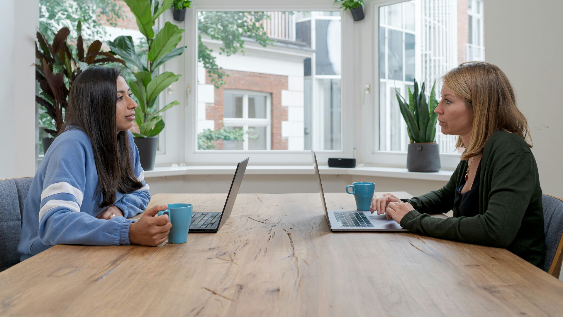 woman in black jacket sitting beside woman in blue long sleeve shirt