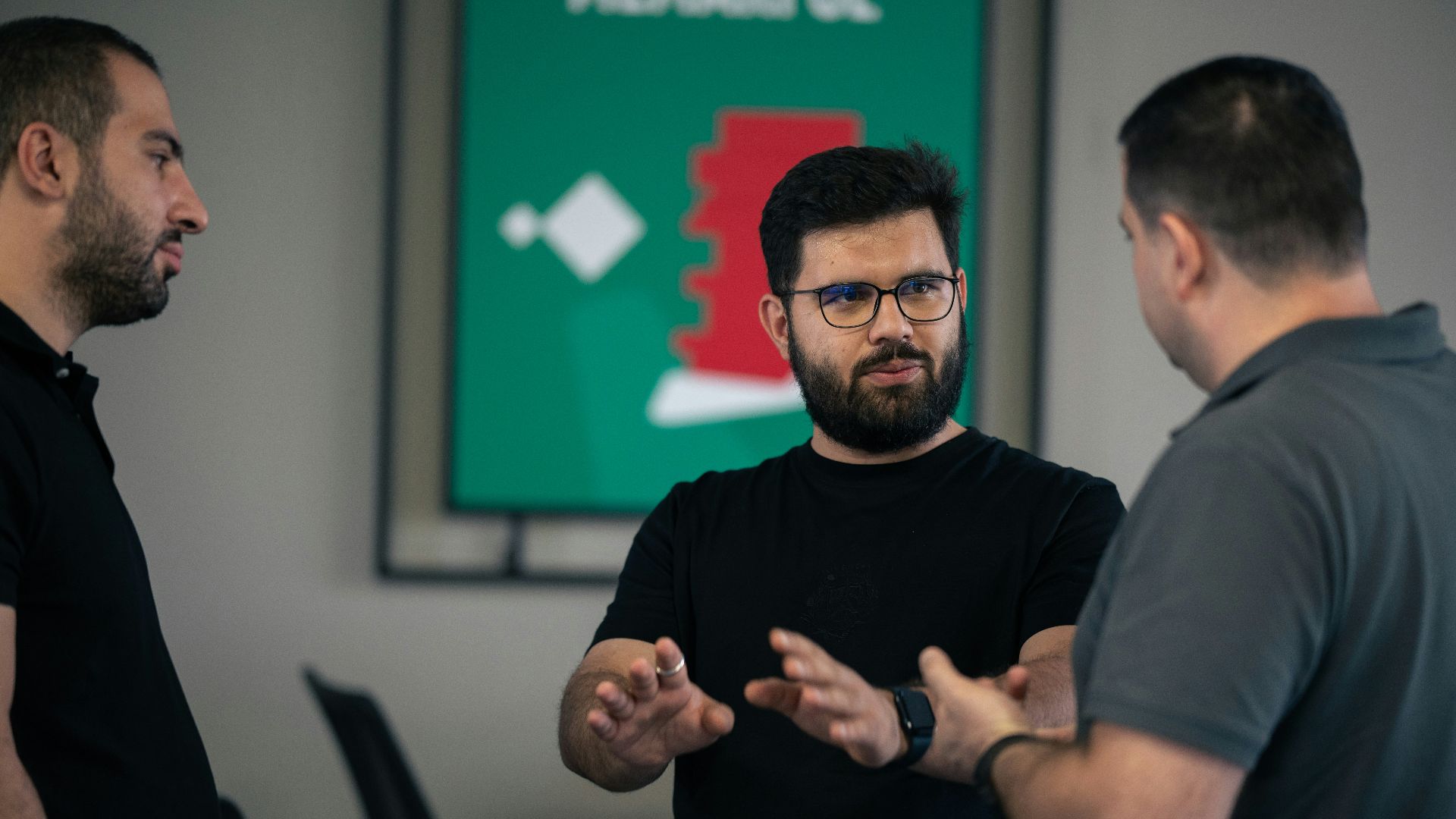 A group of men standing around each other in a room