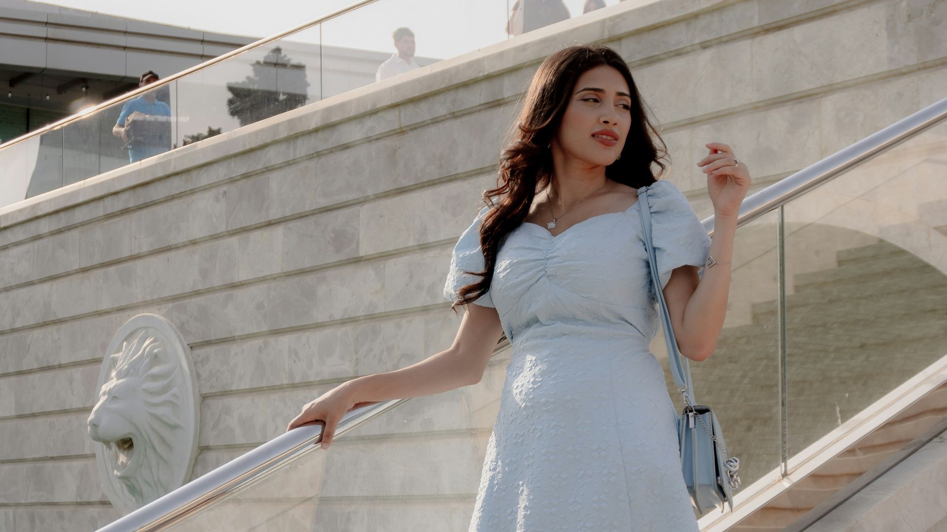 Woman in light blue dress on outdoor stairs
