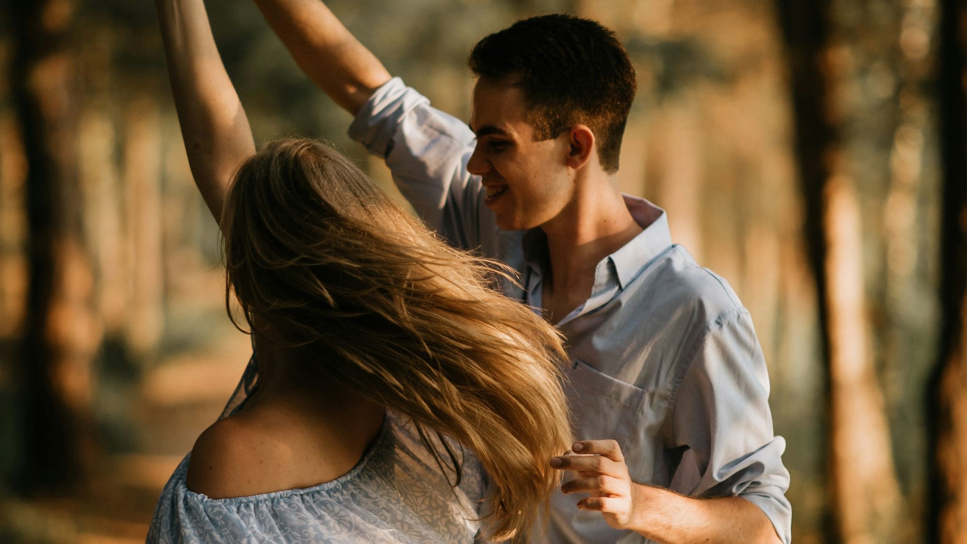 man and woman dancing at center of trees
