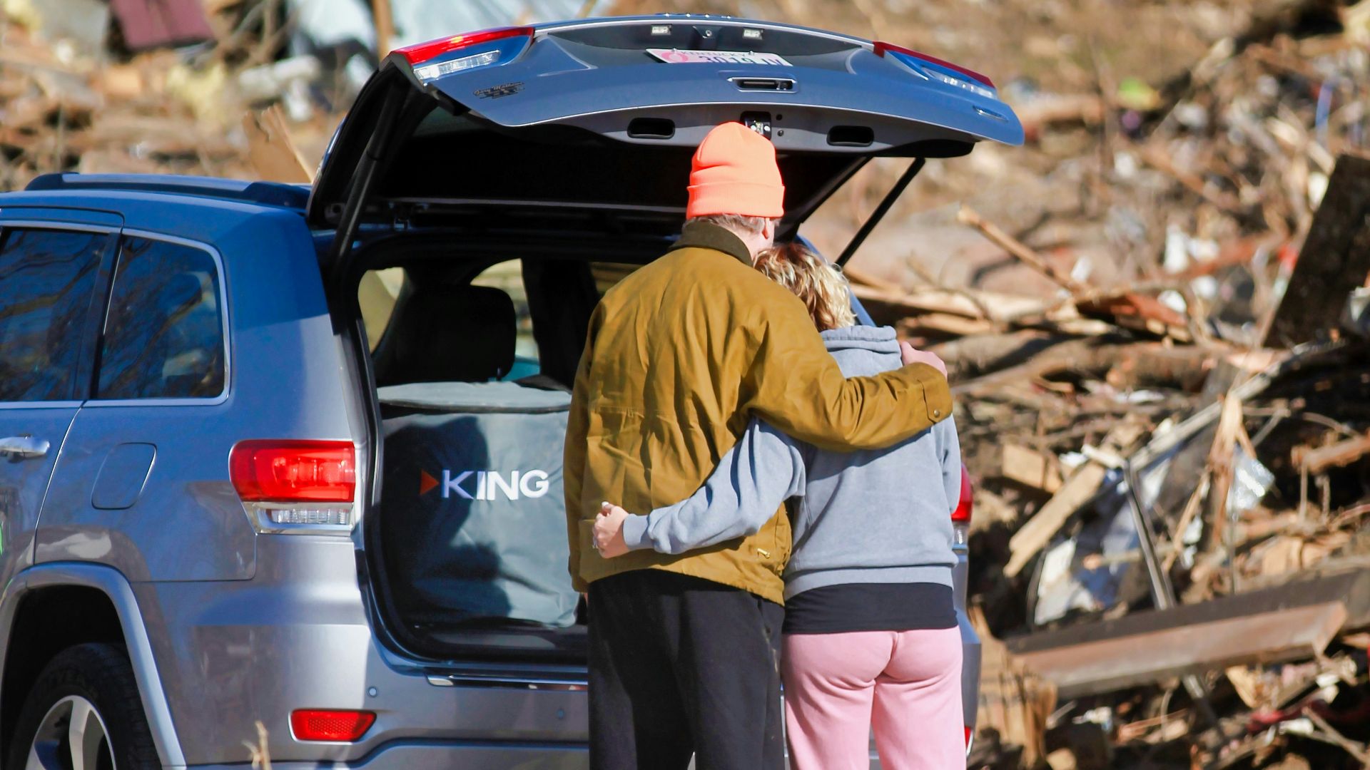 a couple of people standing next to a car