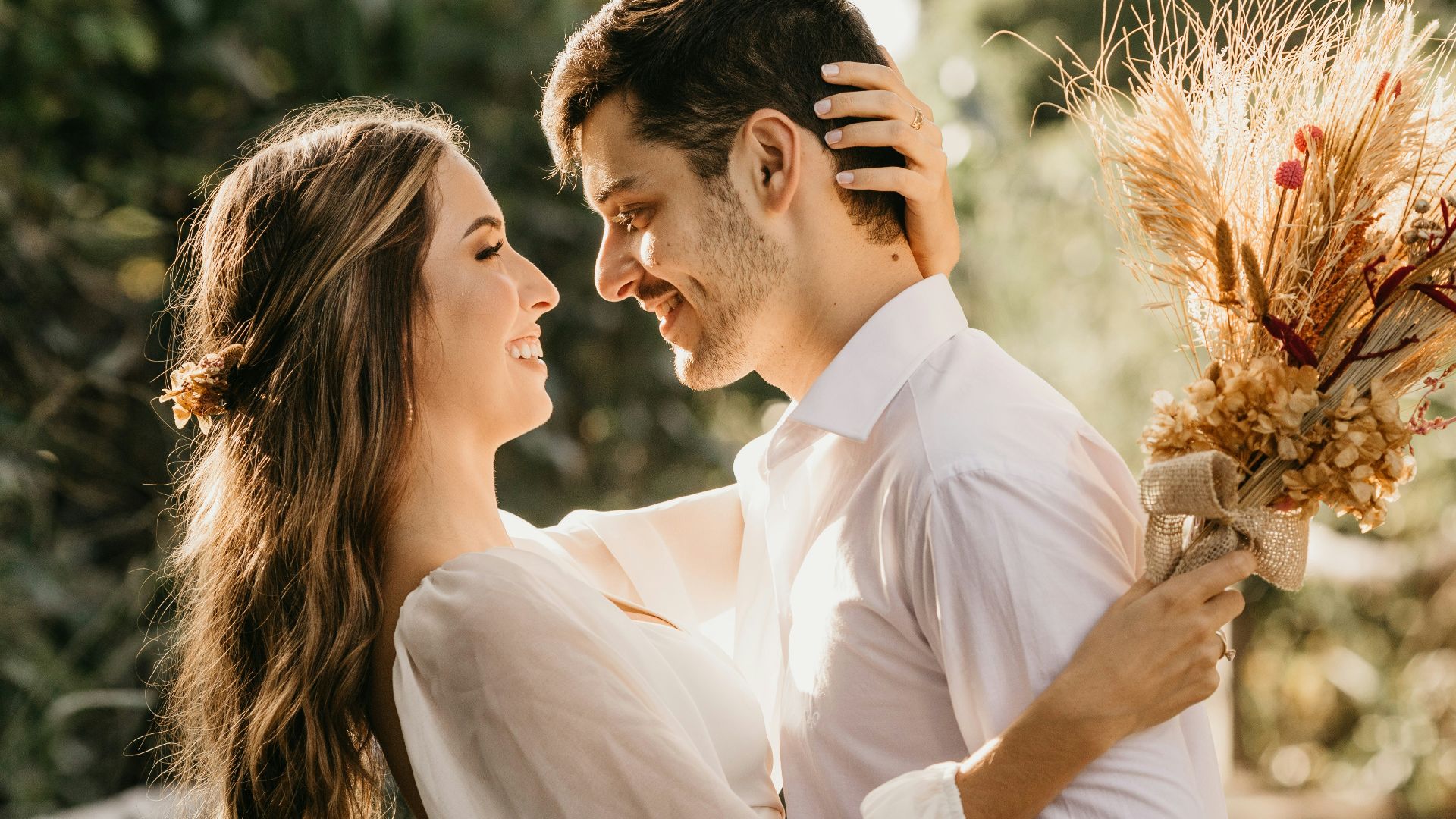 man in white dress shirt holding brown flower bouquet