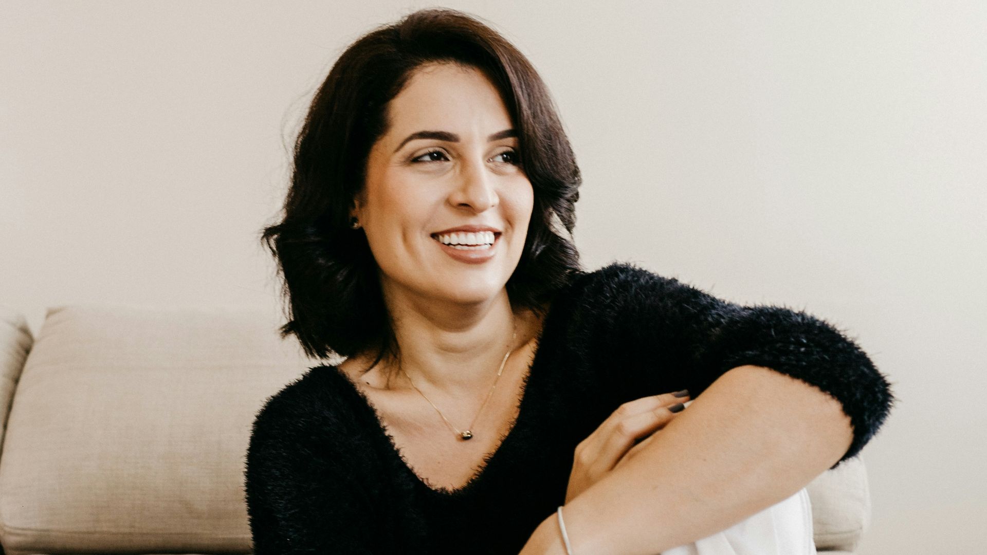 woman in black long sleeve shirt sitting on white couch