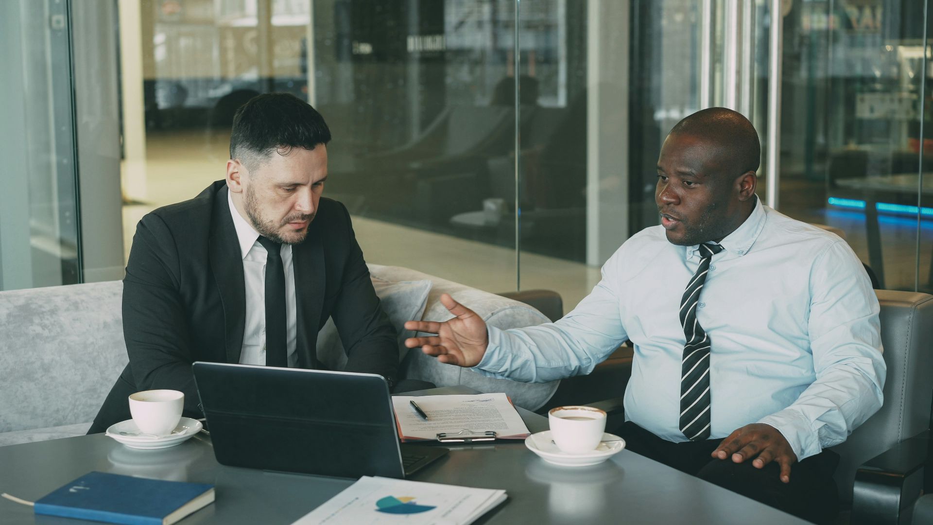 Two businessmen discussing a project at a table.