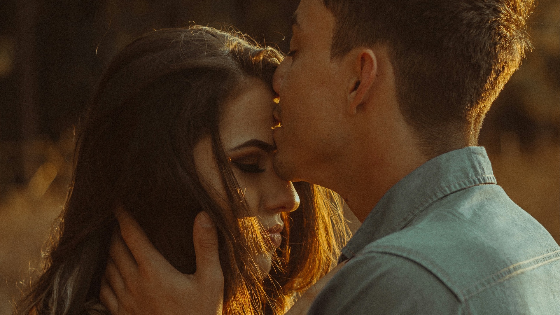 man kissing woman forehead