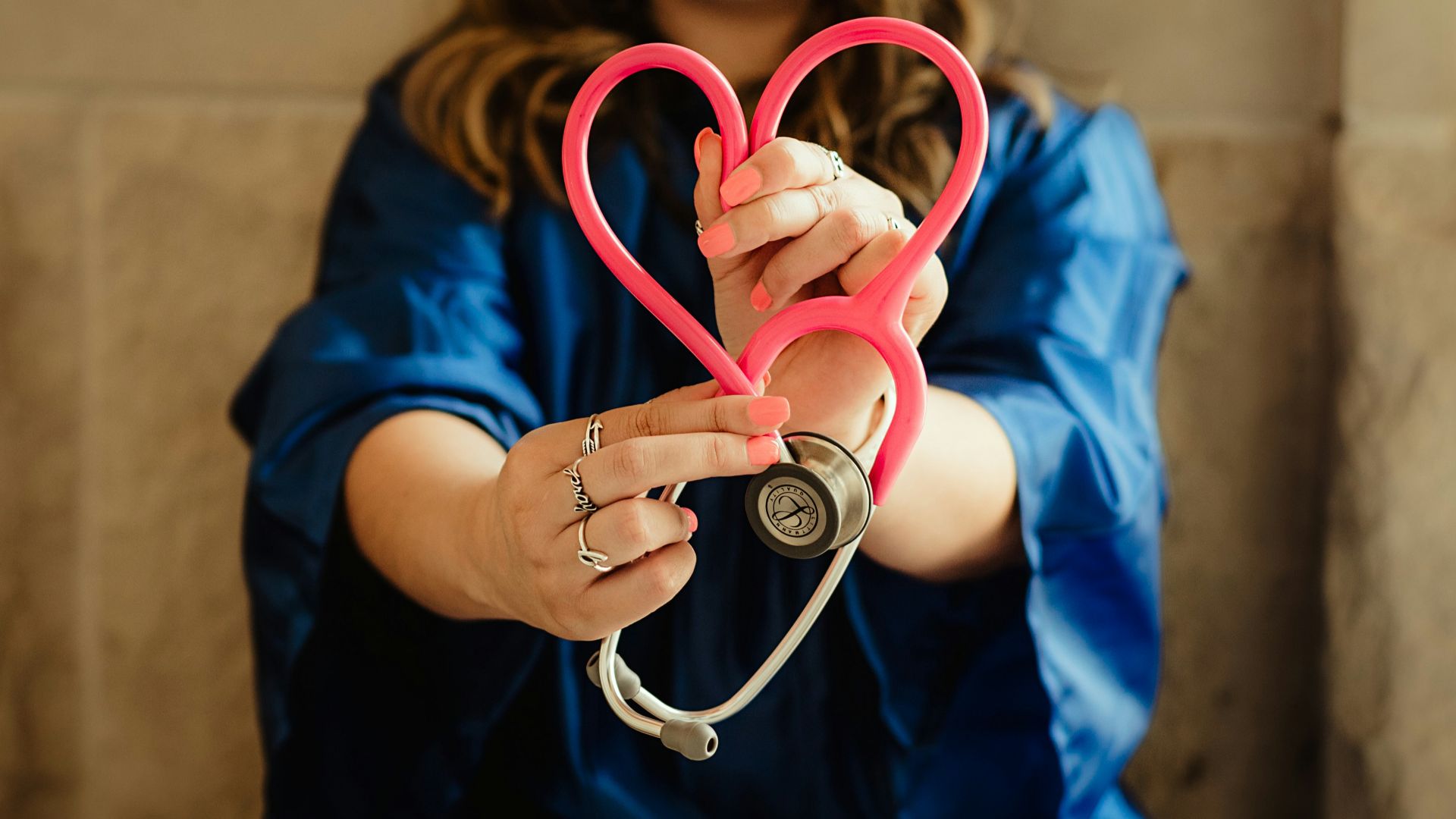 girl in blue jacket holding red and silver ring