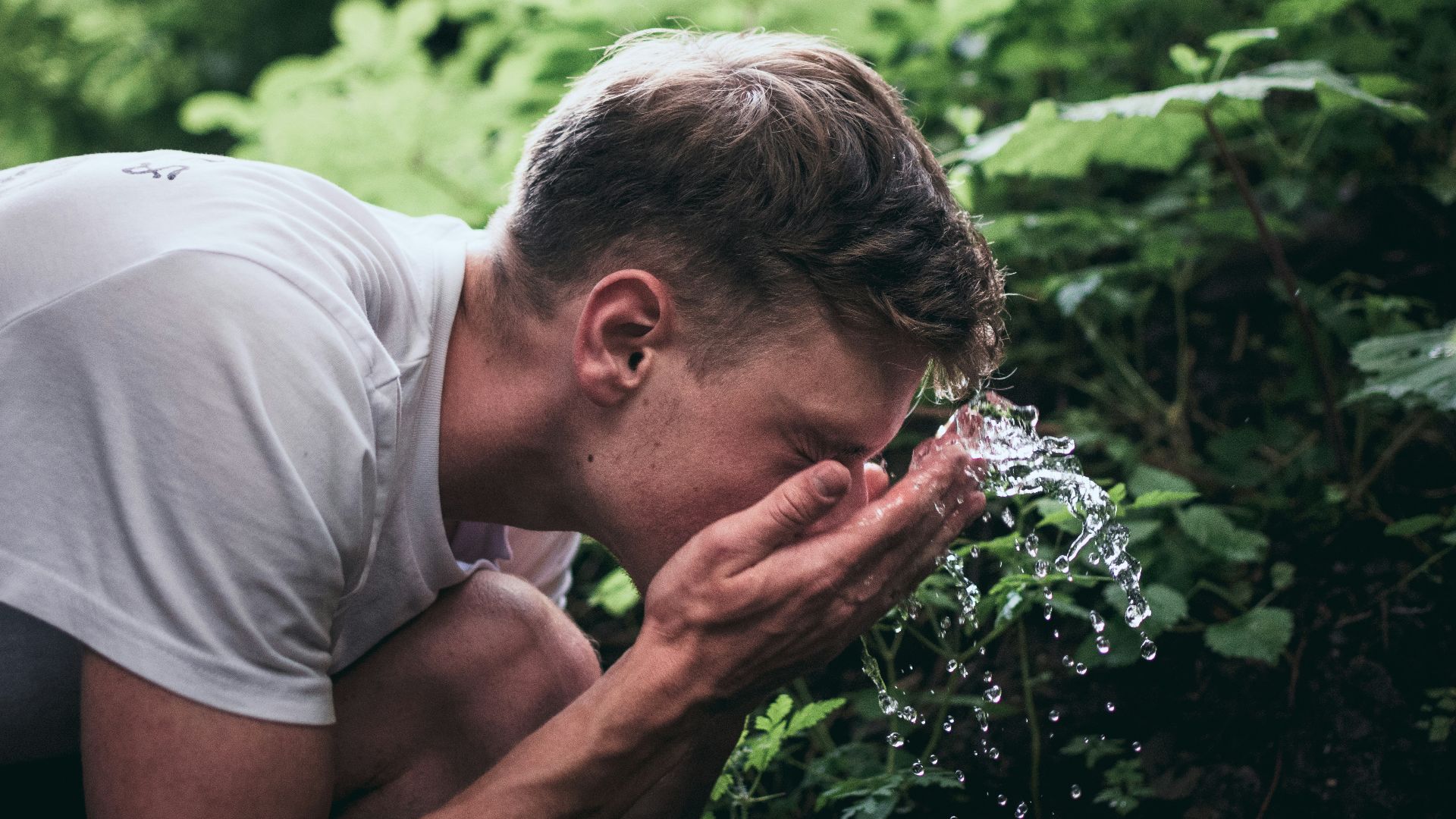 man washing his face