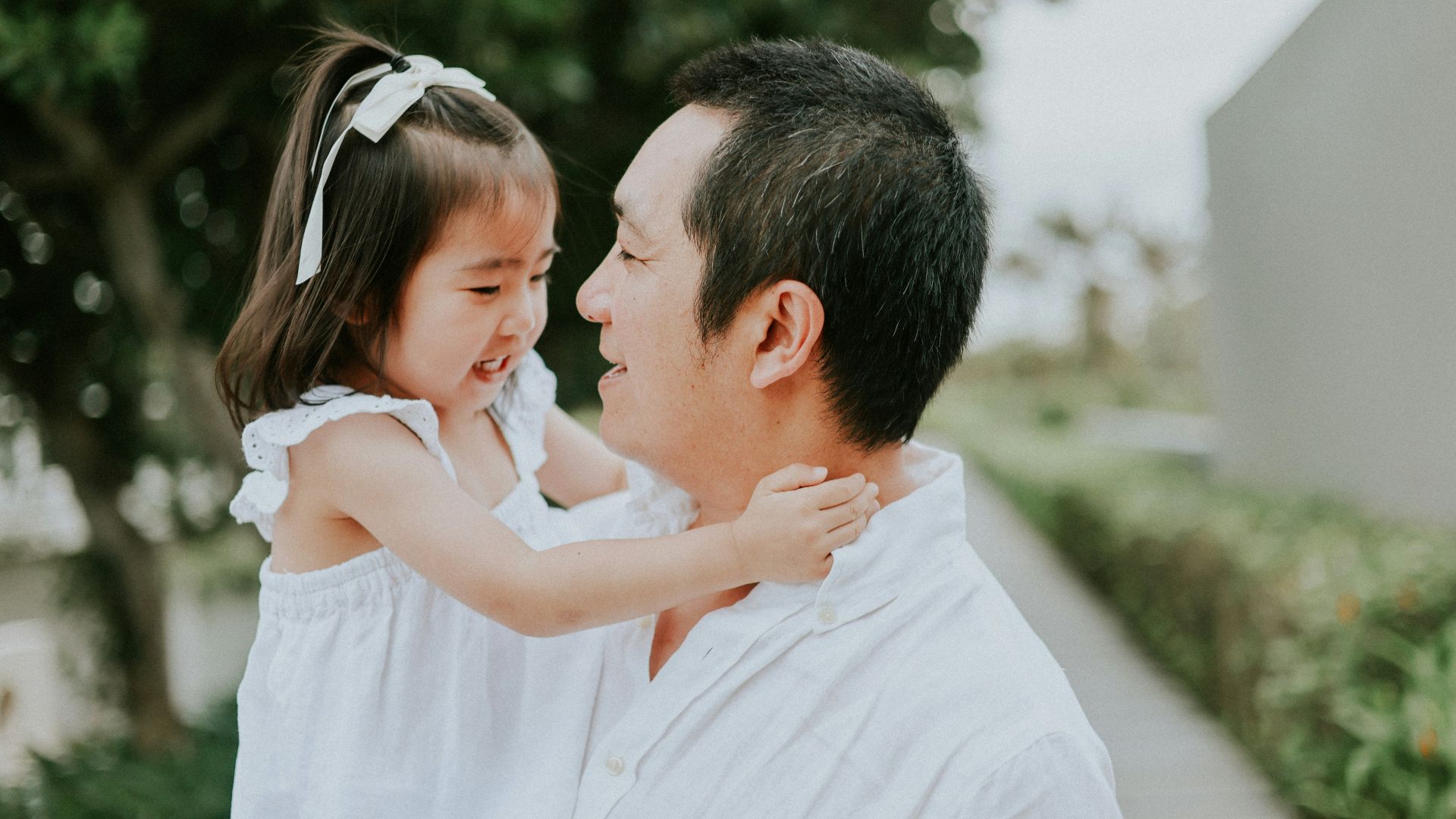 Father holds his young daughter outdoors