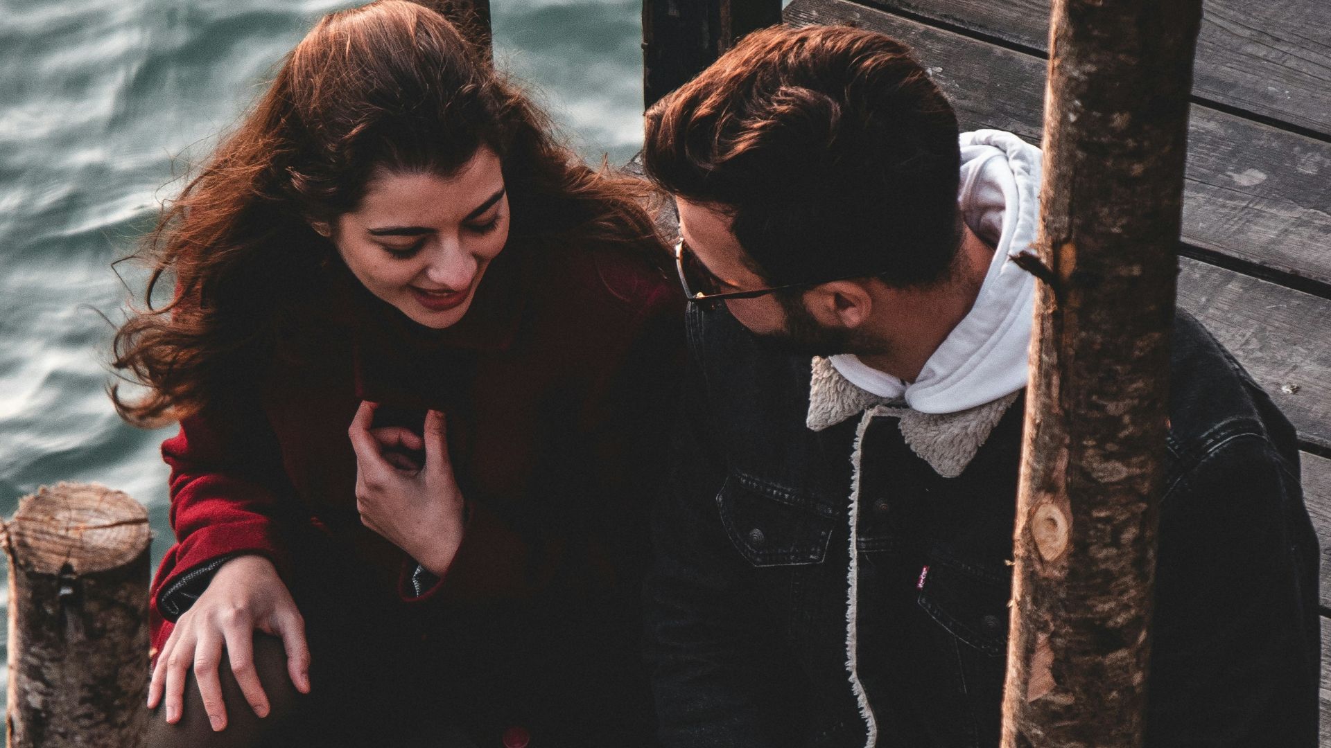 a man and a woman sitting on a dock