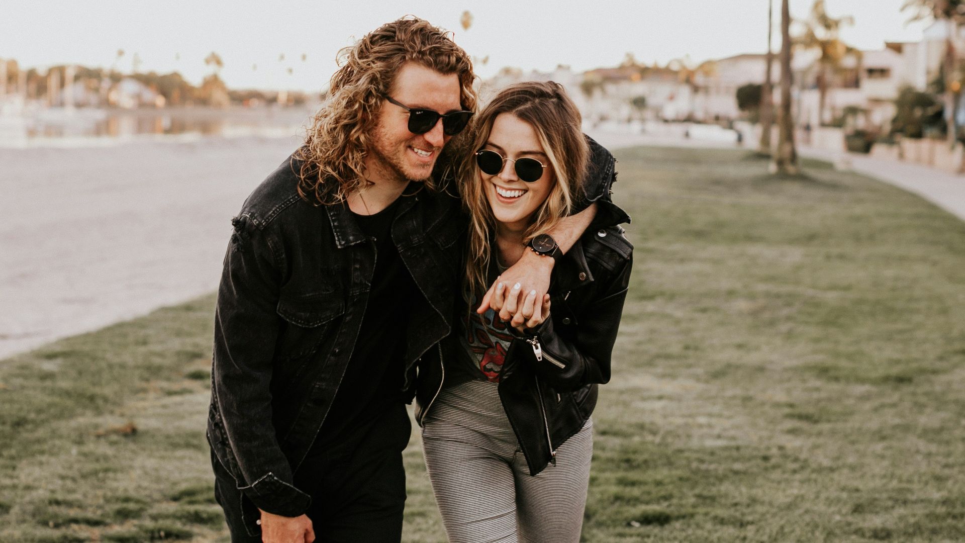 woman in black leather jacket and gray pants standing on green grass field during daytime