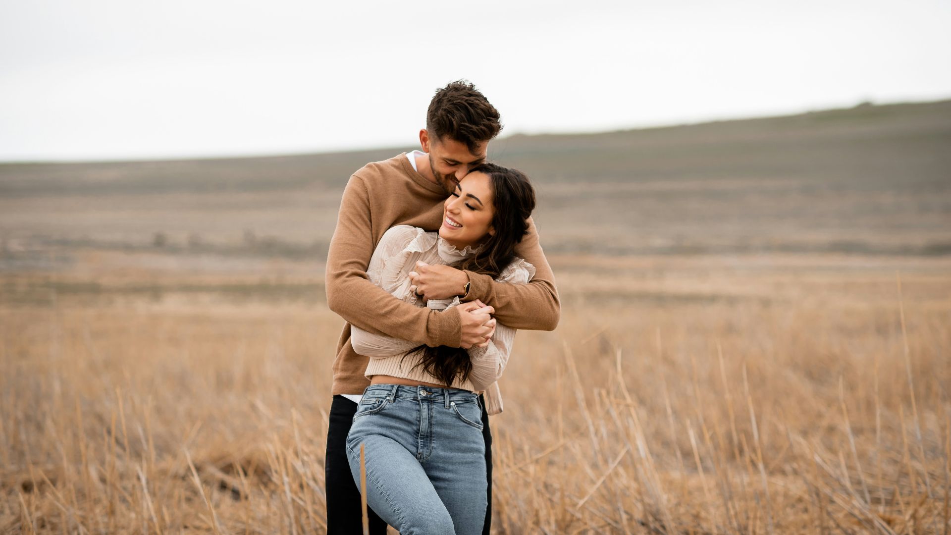 A man and a woman hugging in a field