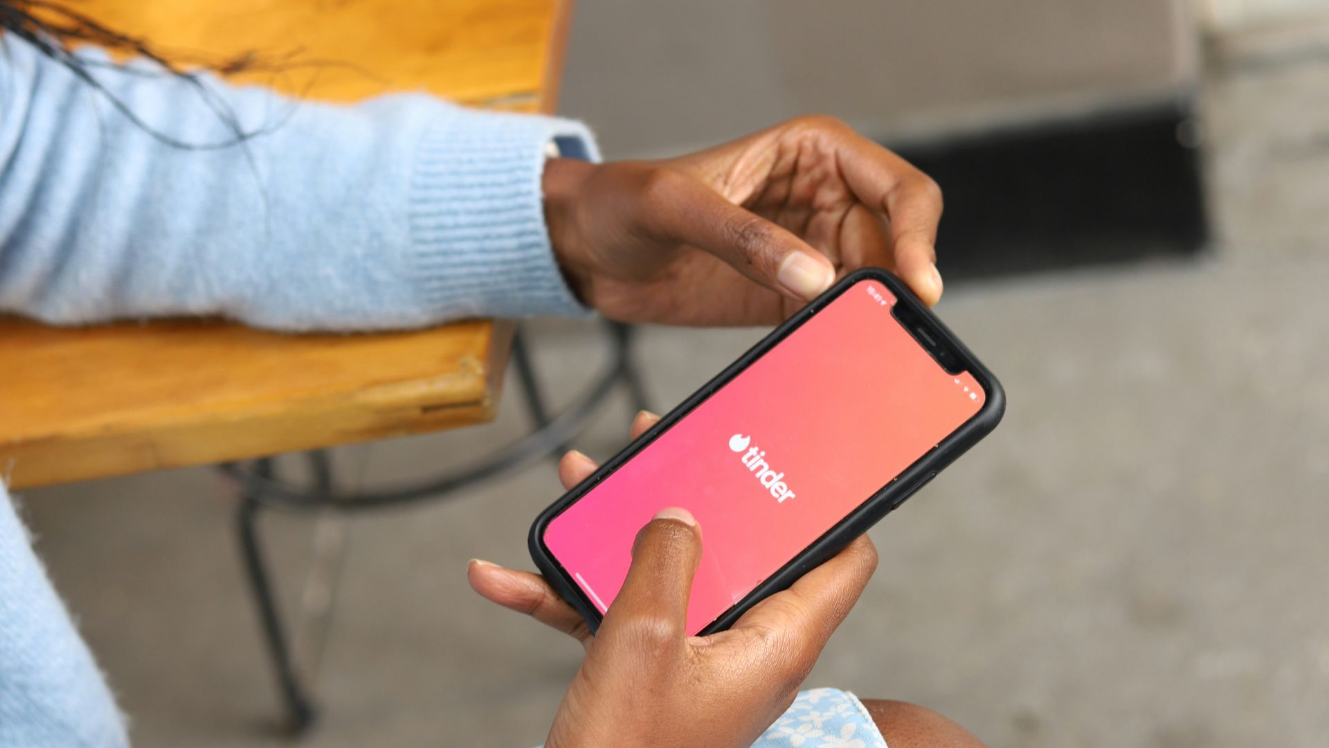 a woman sitting on a bench holding a cell phone