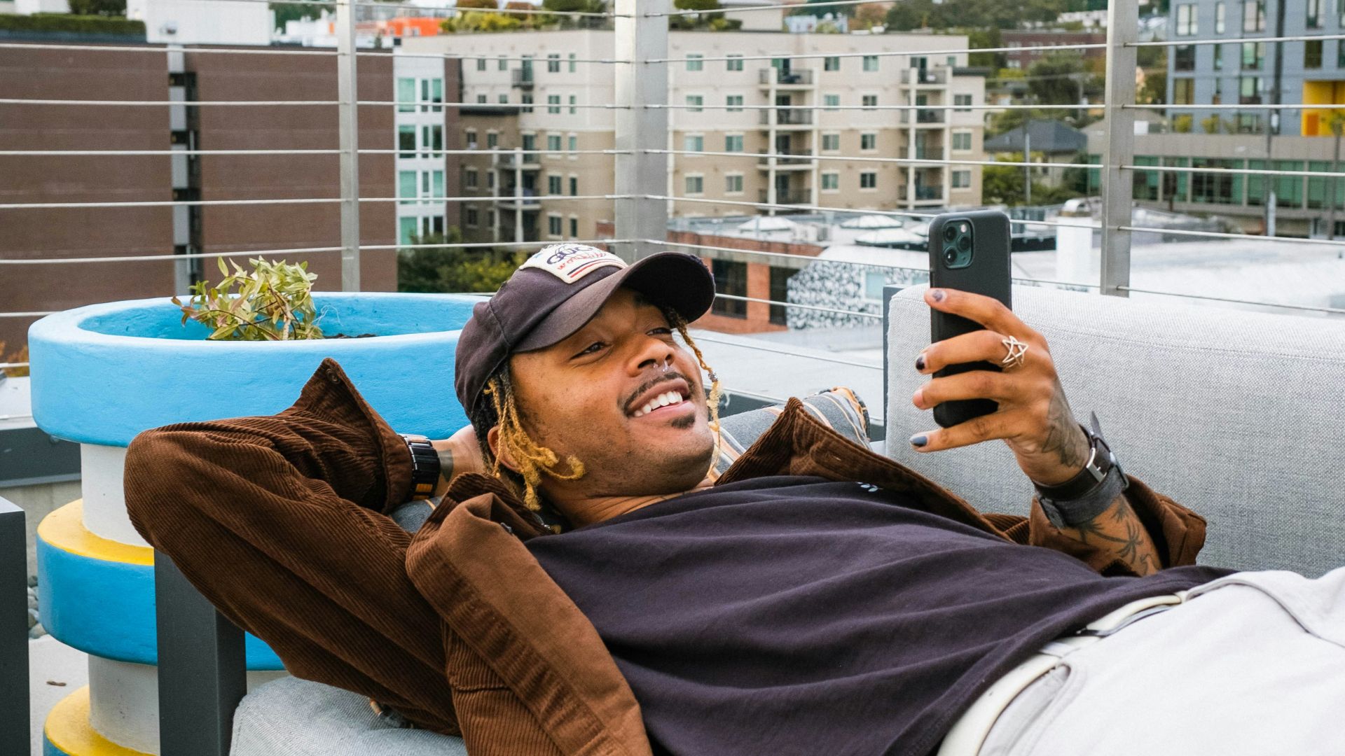 a man laying on a couch taking a picture of himself