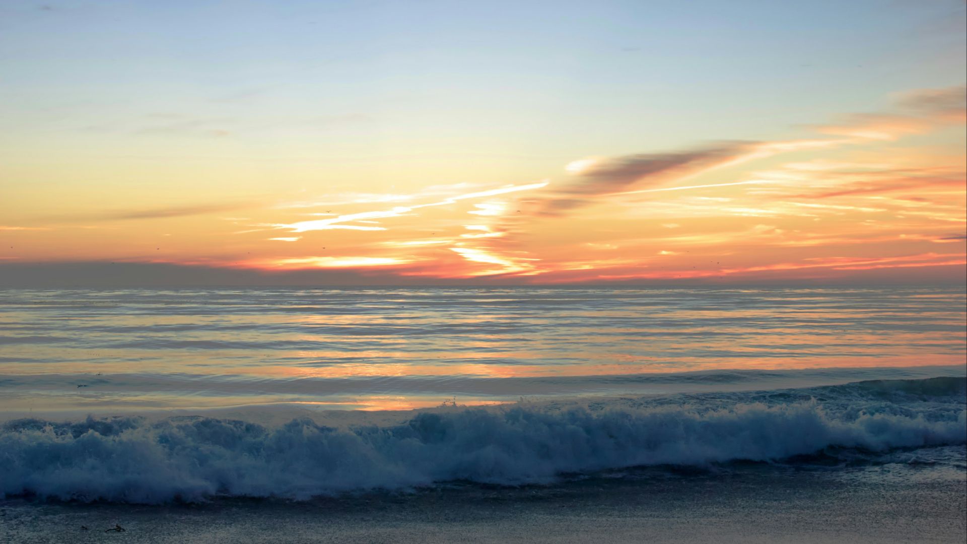 the sun is setting over the ocean with waves