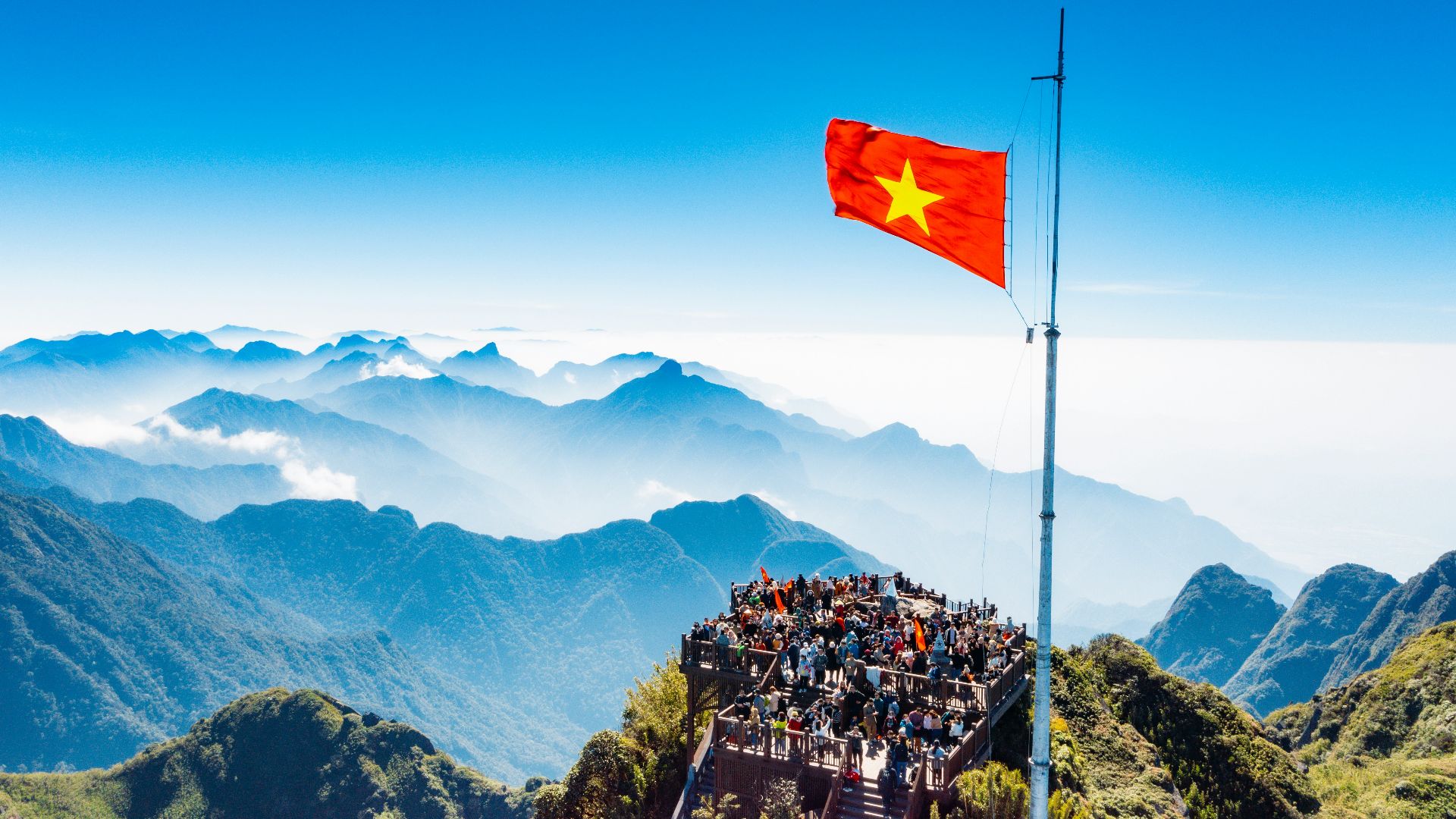 a large group of people standing on top of a mountain