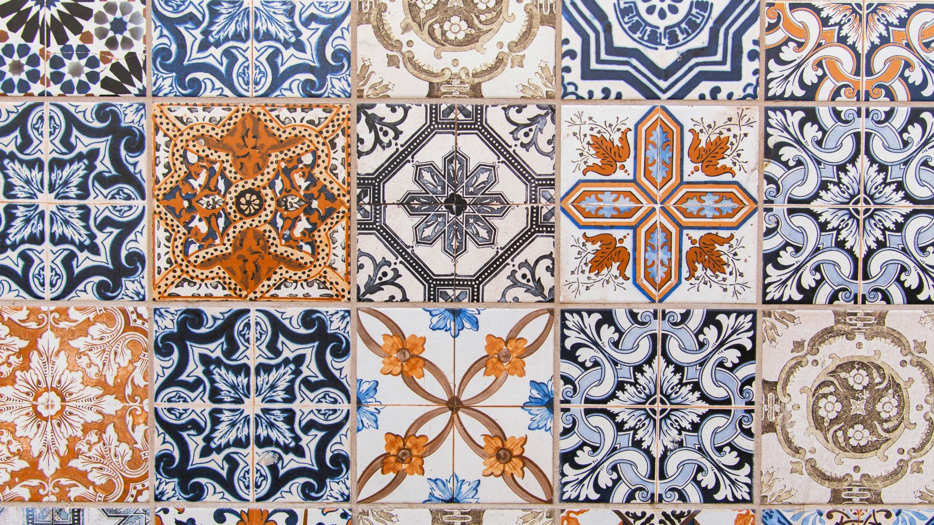a close up of a tiled wall with different designs