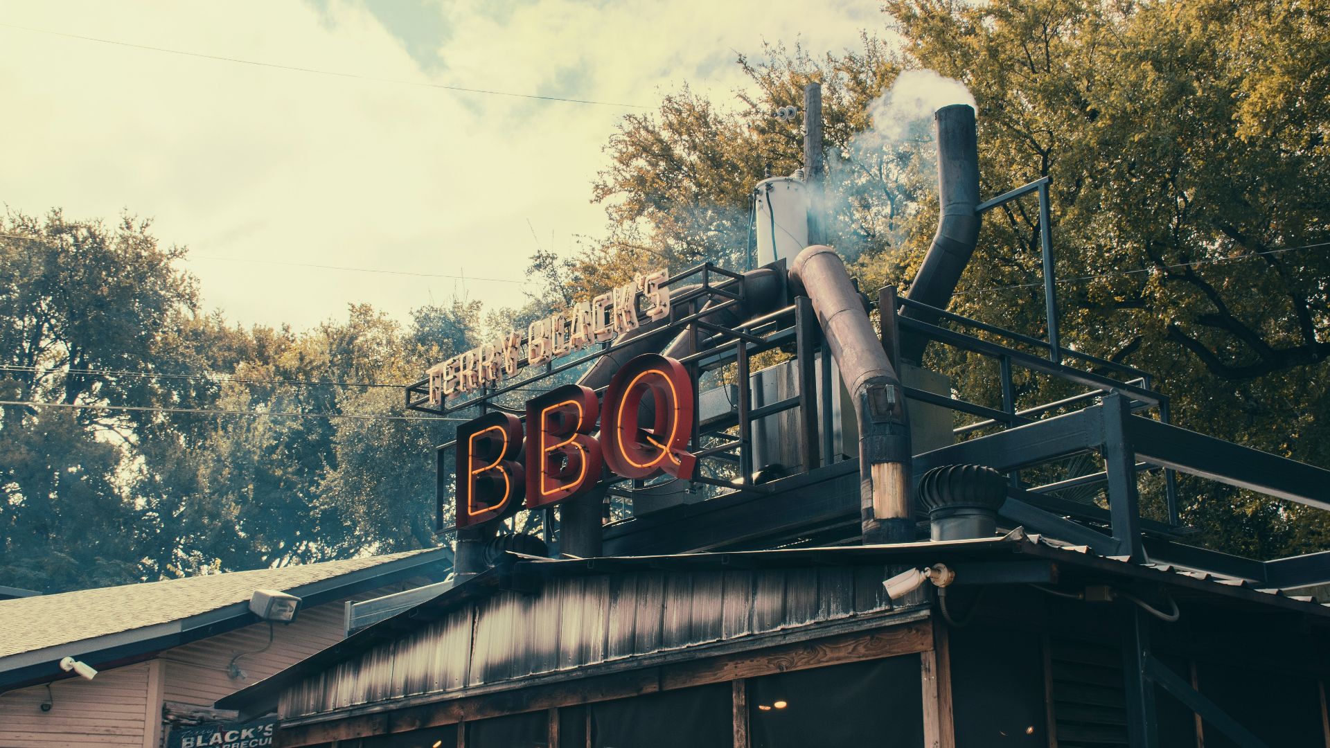 a bbq sign on top of a building with smoke coming out of it