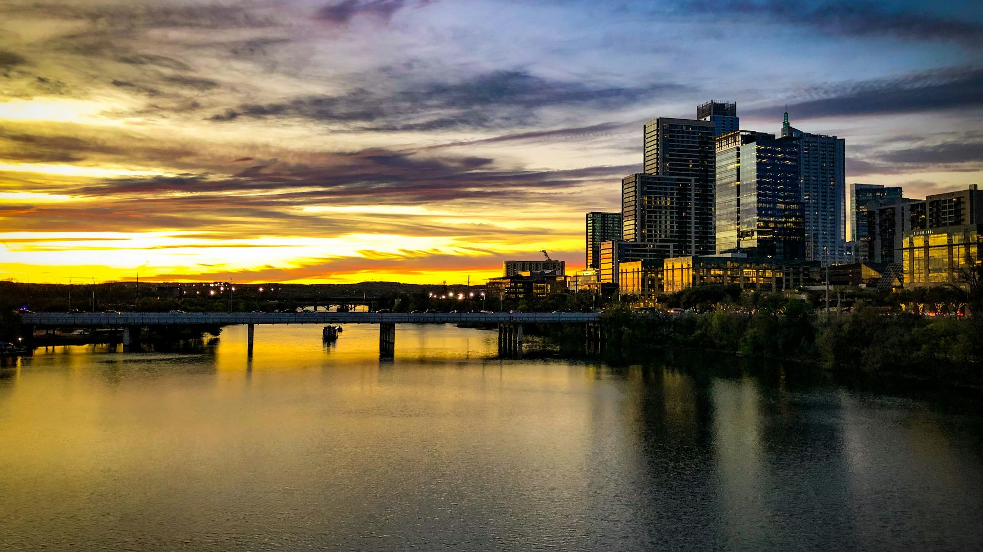 city skyline across body of water during sunset