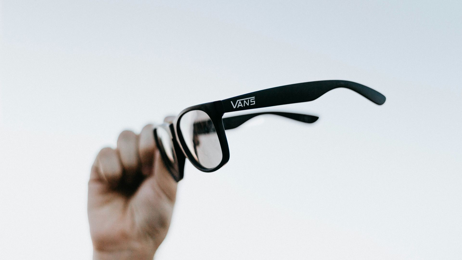 a hand holding up a pair of glasses