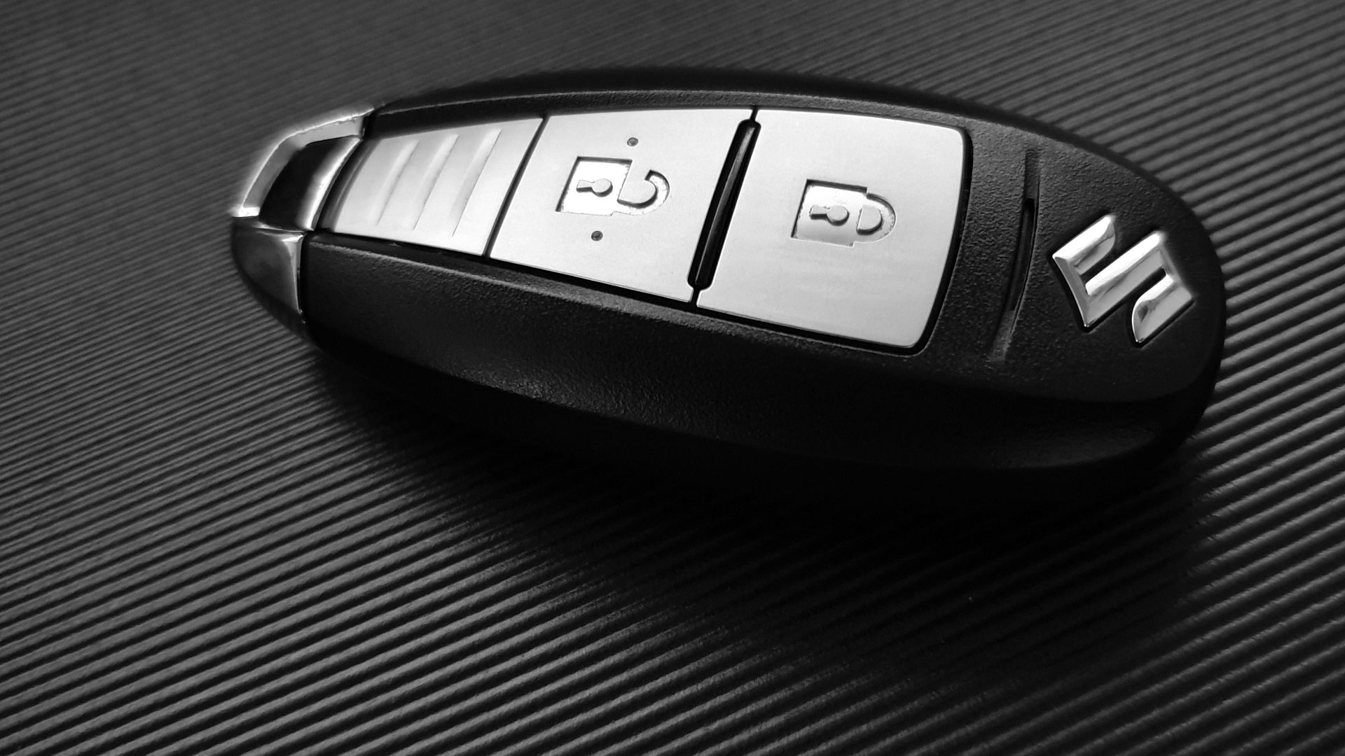 gray and black Suzuki car fob on black surface