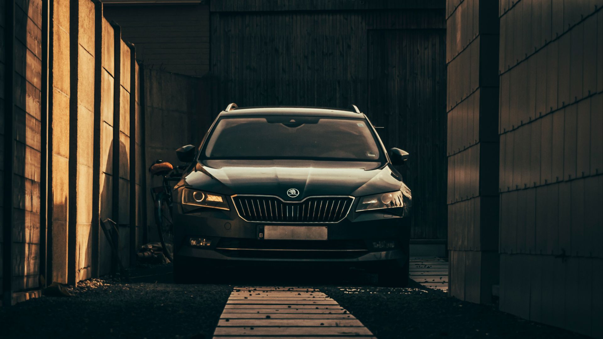 grayscale photo of car parked beside building