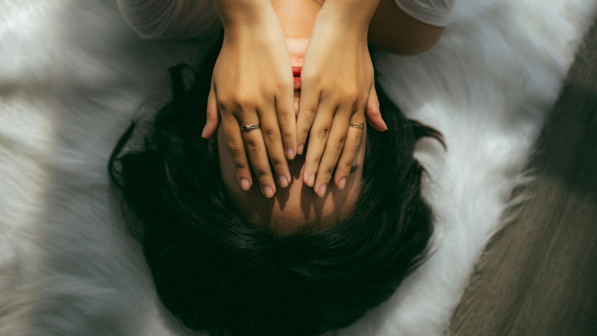 a woman holds her hands over her face