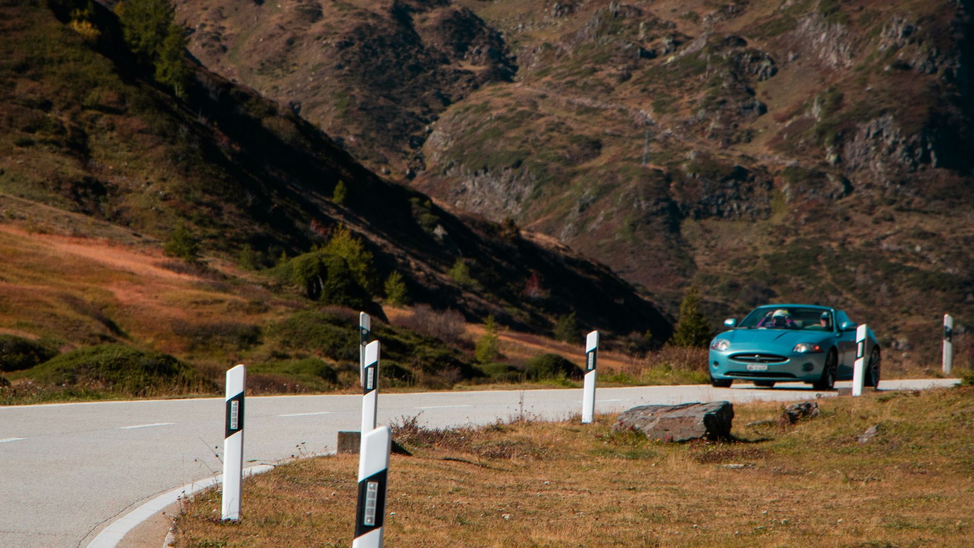 a blue car is parked on the side of the road