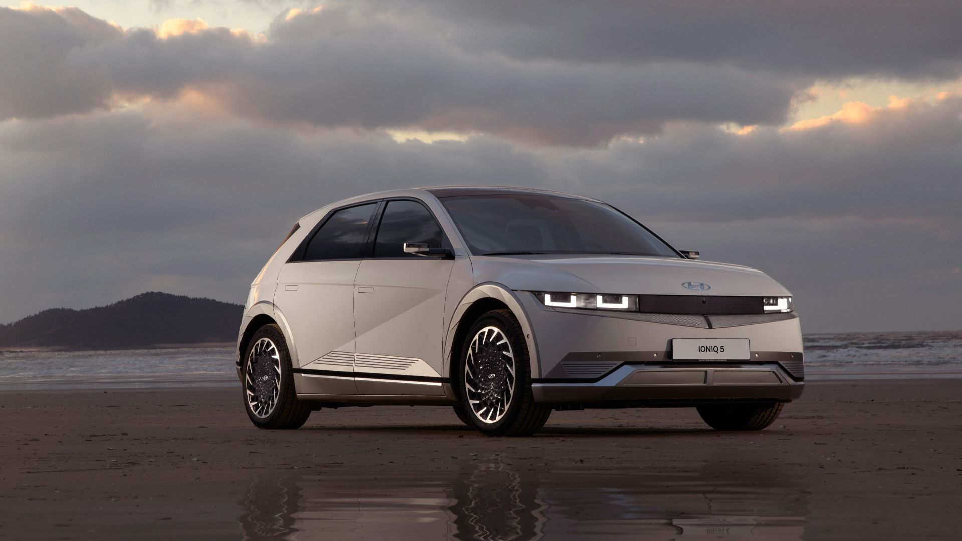 a white car parked on top of a sandy beach