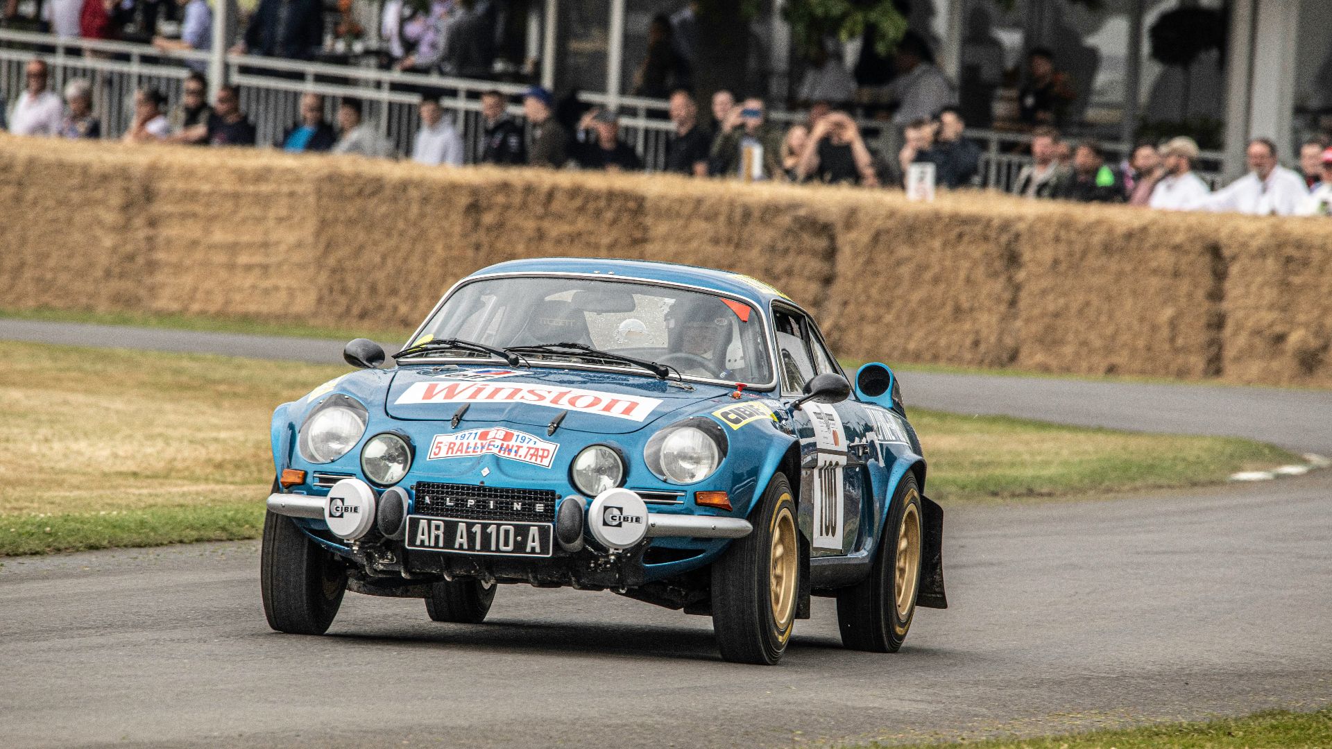 A blue car driving down a race track