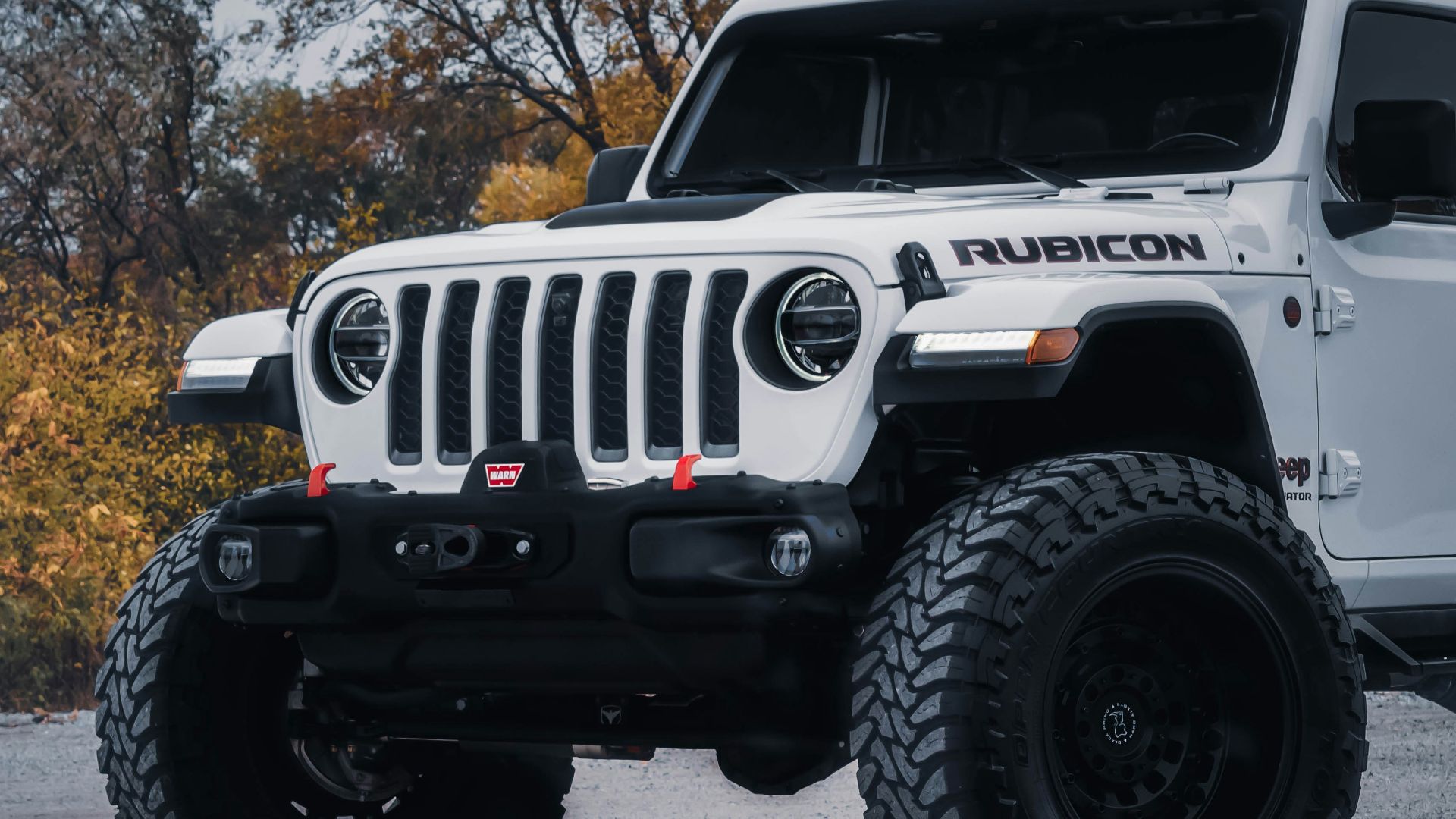 a white jeep is parked in a parking lot