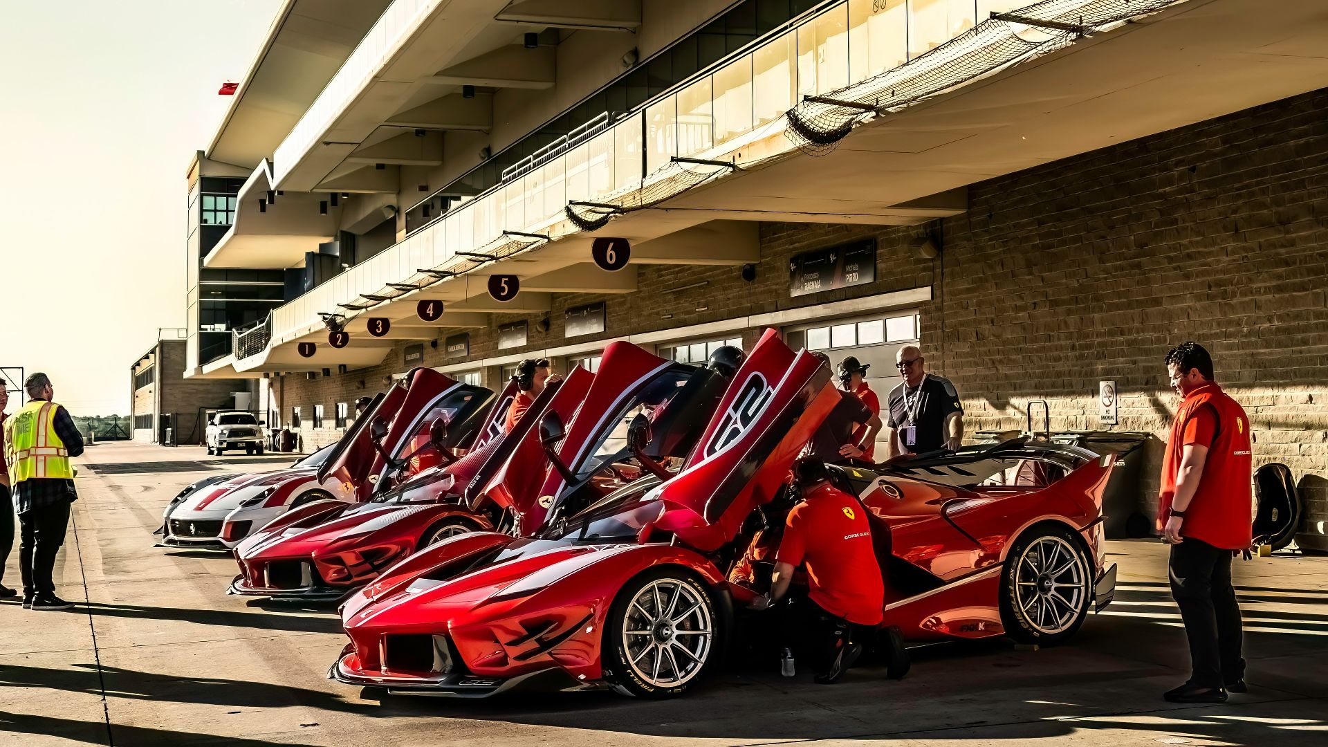 A row of red sports cars parked in front of a building