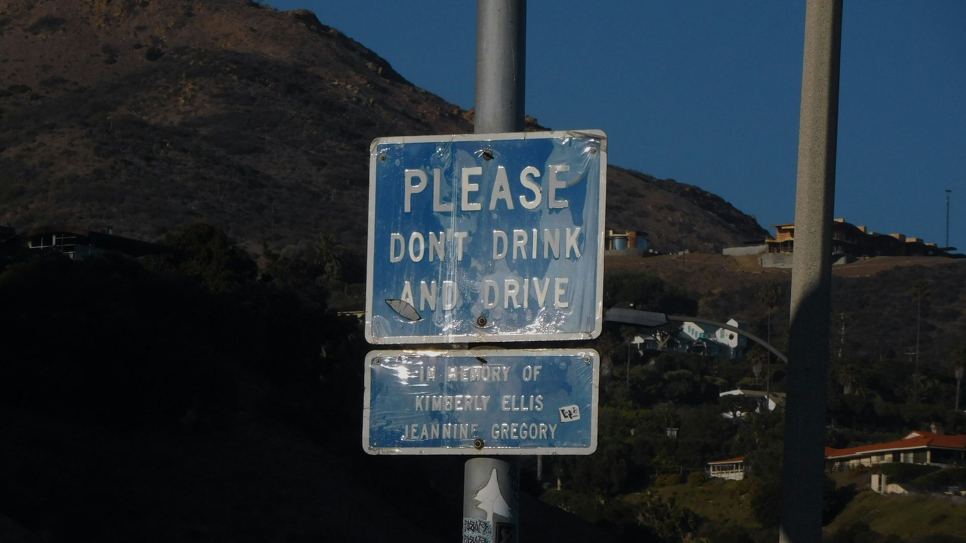 a blue and white street sign sitting on the side of a road
