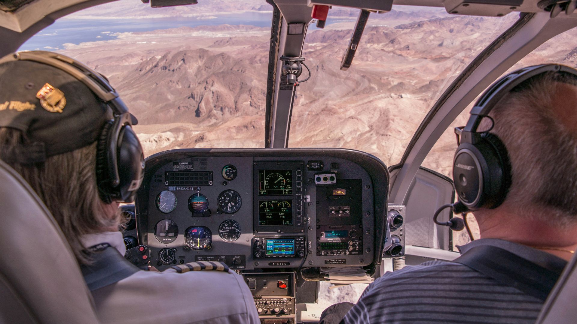 two person riding plane near mountains during daytime