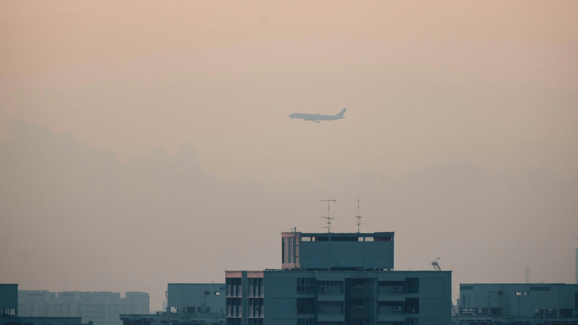 airplane flying over buildings
