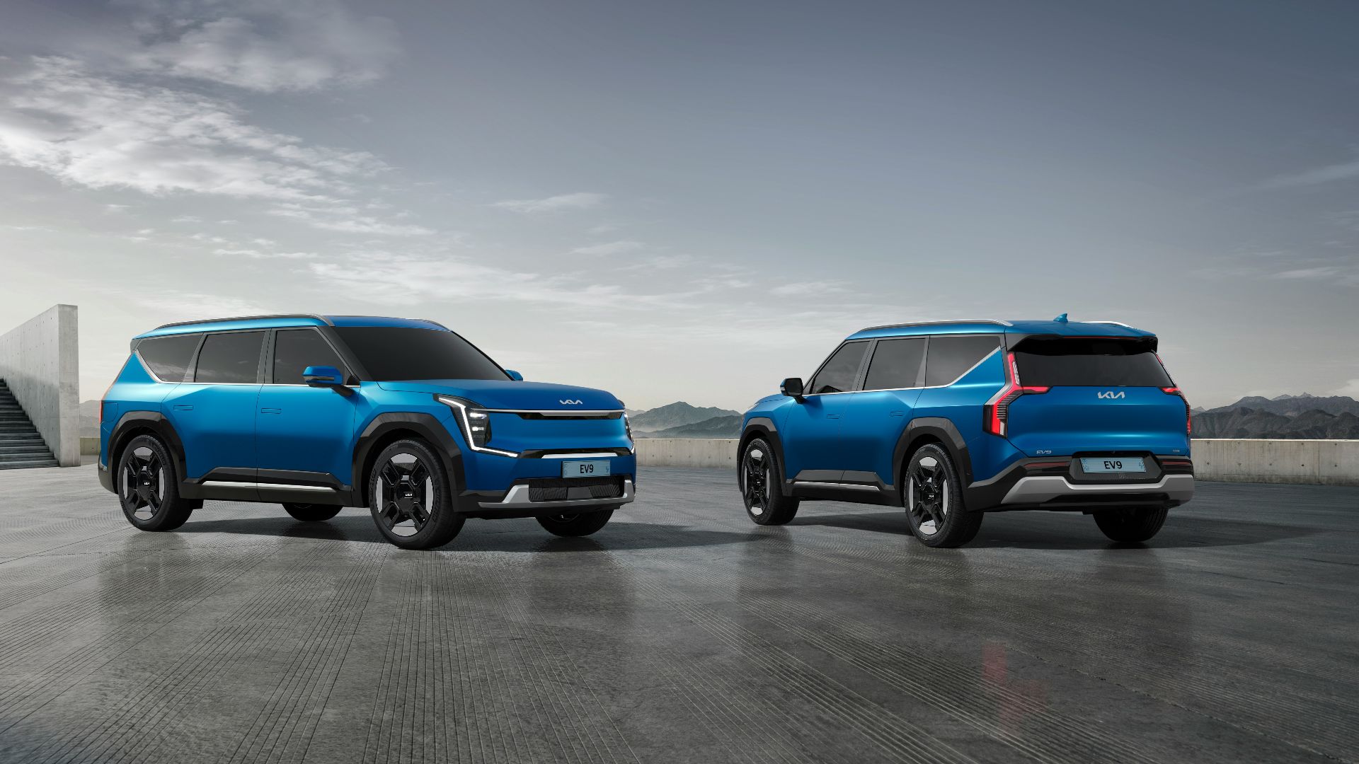 two blue suvs side by side in a parking lot