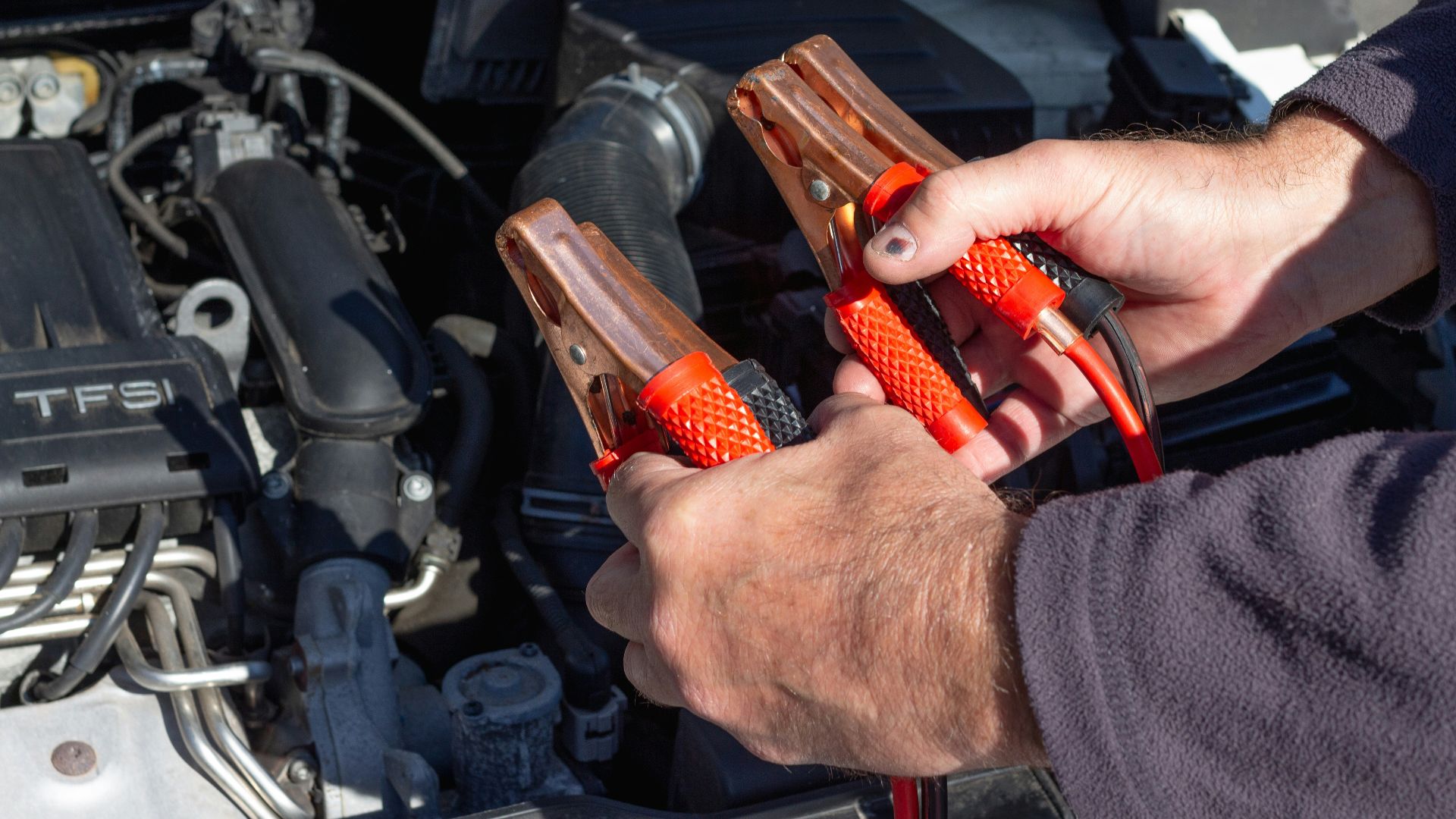 person holding red and black hand tool