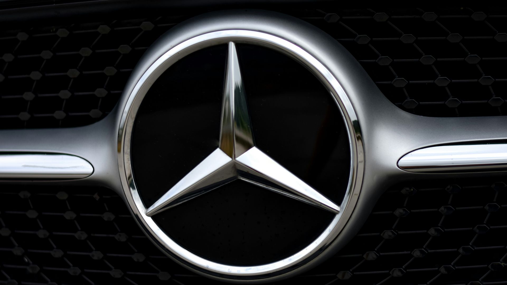 silver mercedes benz emblem on black car