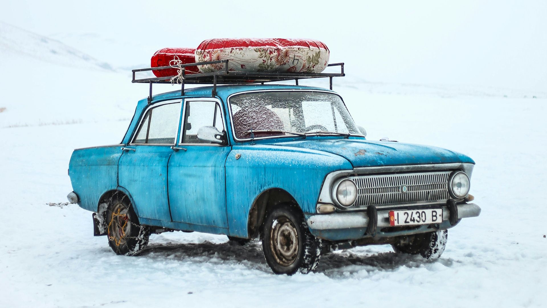 blue sedan on snow ground