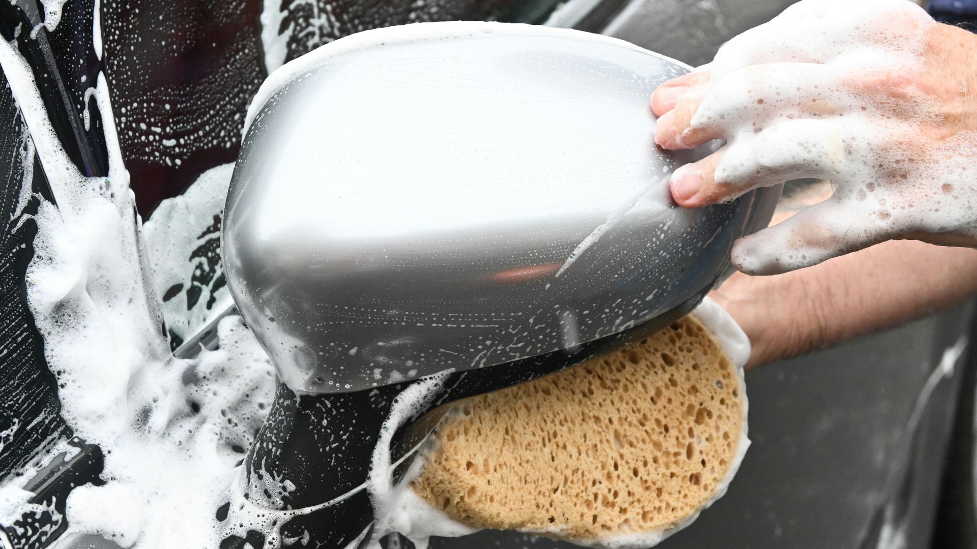 a person washing a car with a sponge