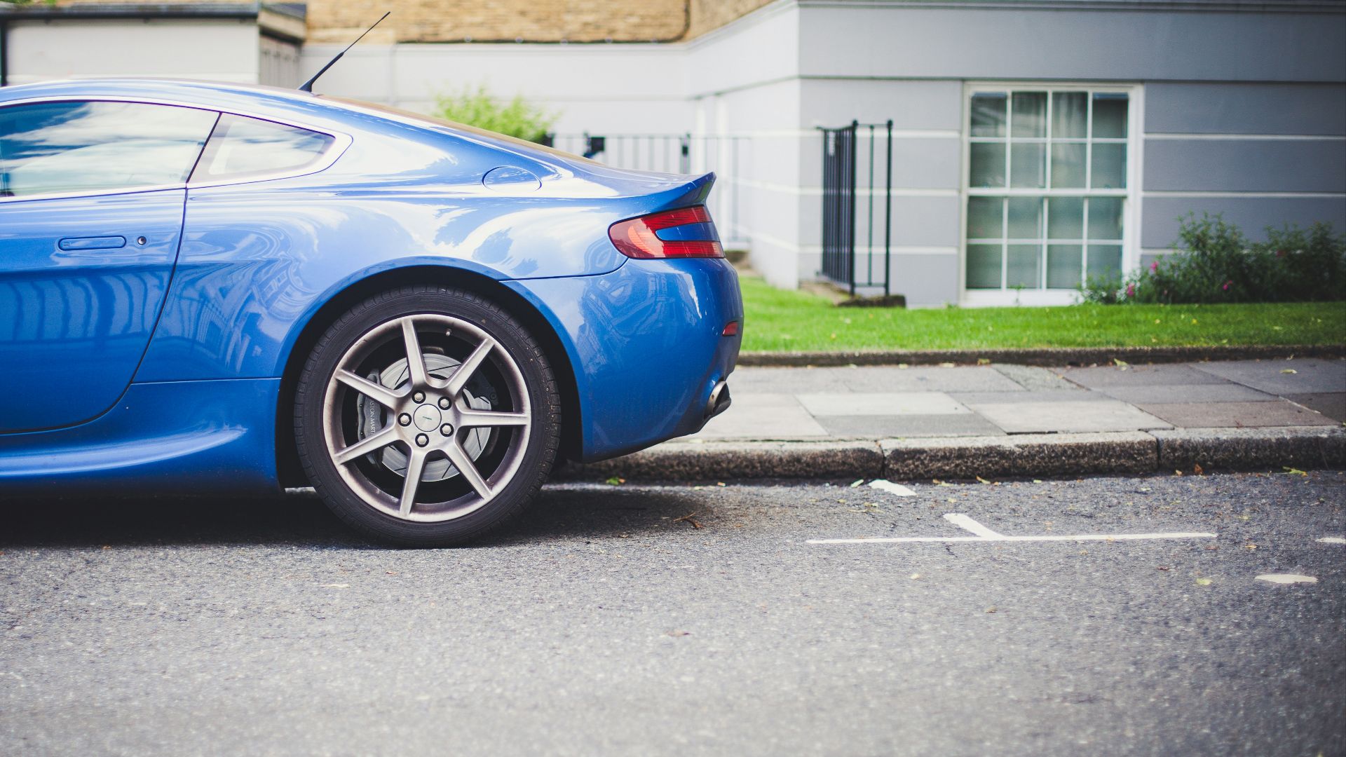 blue coupe parked in front of house