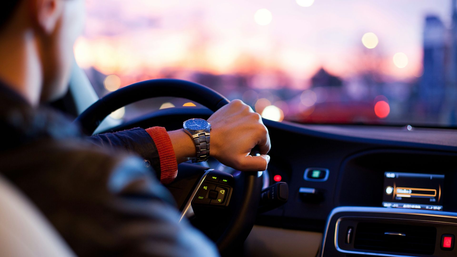 man driving a car wearing wrist watch