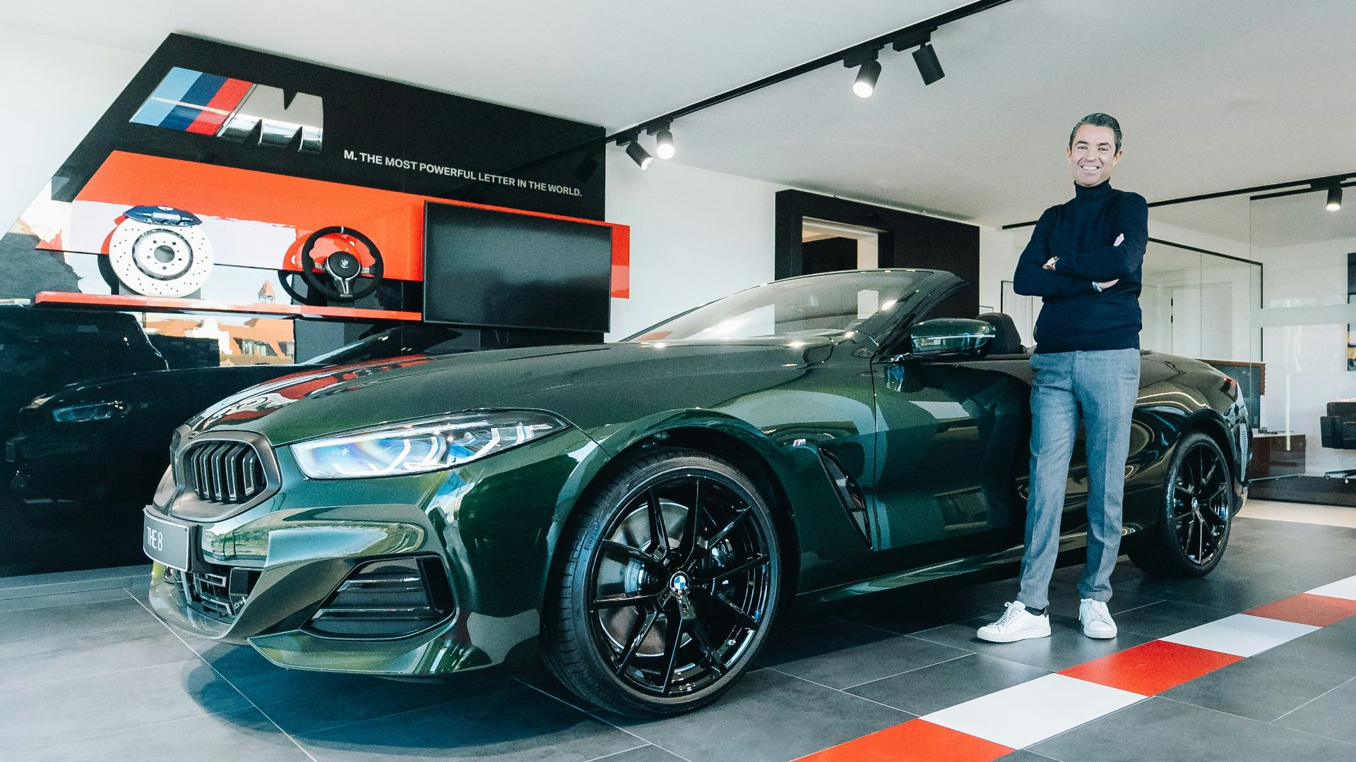 a man standing next to a green sports car