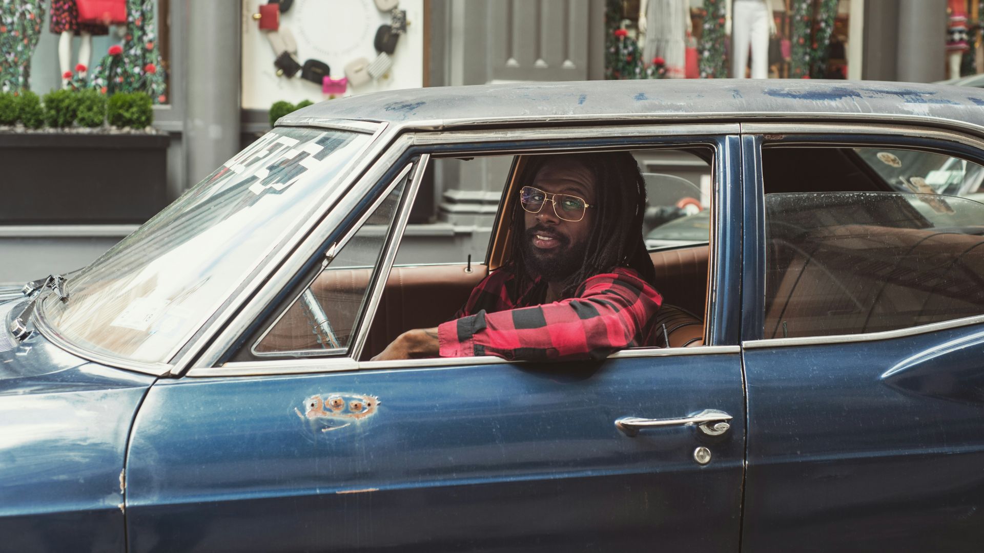 man driving blue car