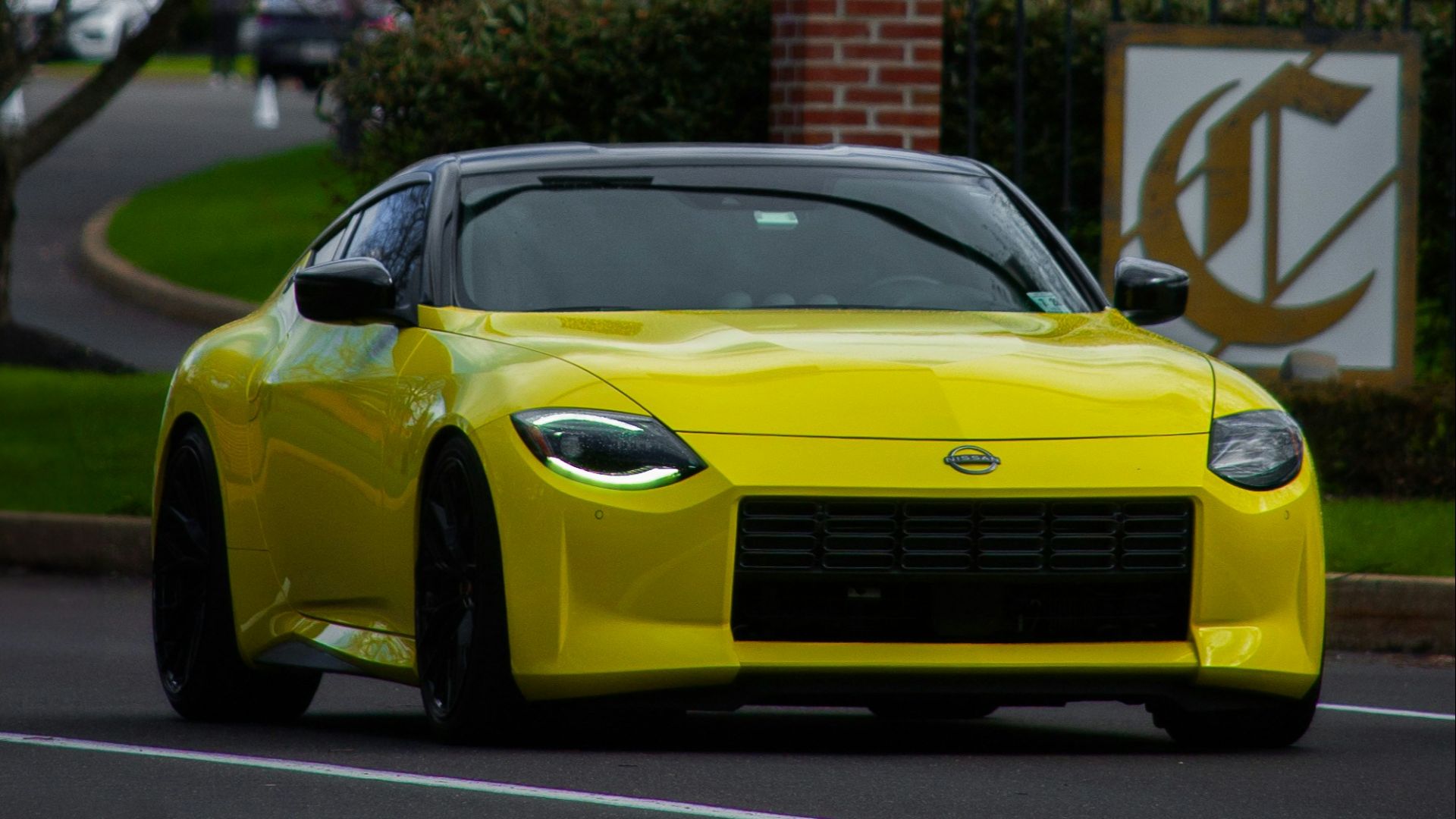 a yellow sports car driving down a street