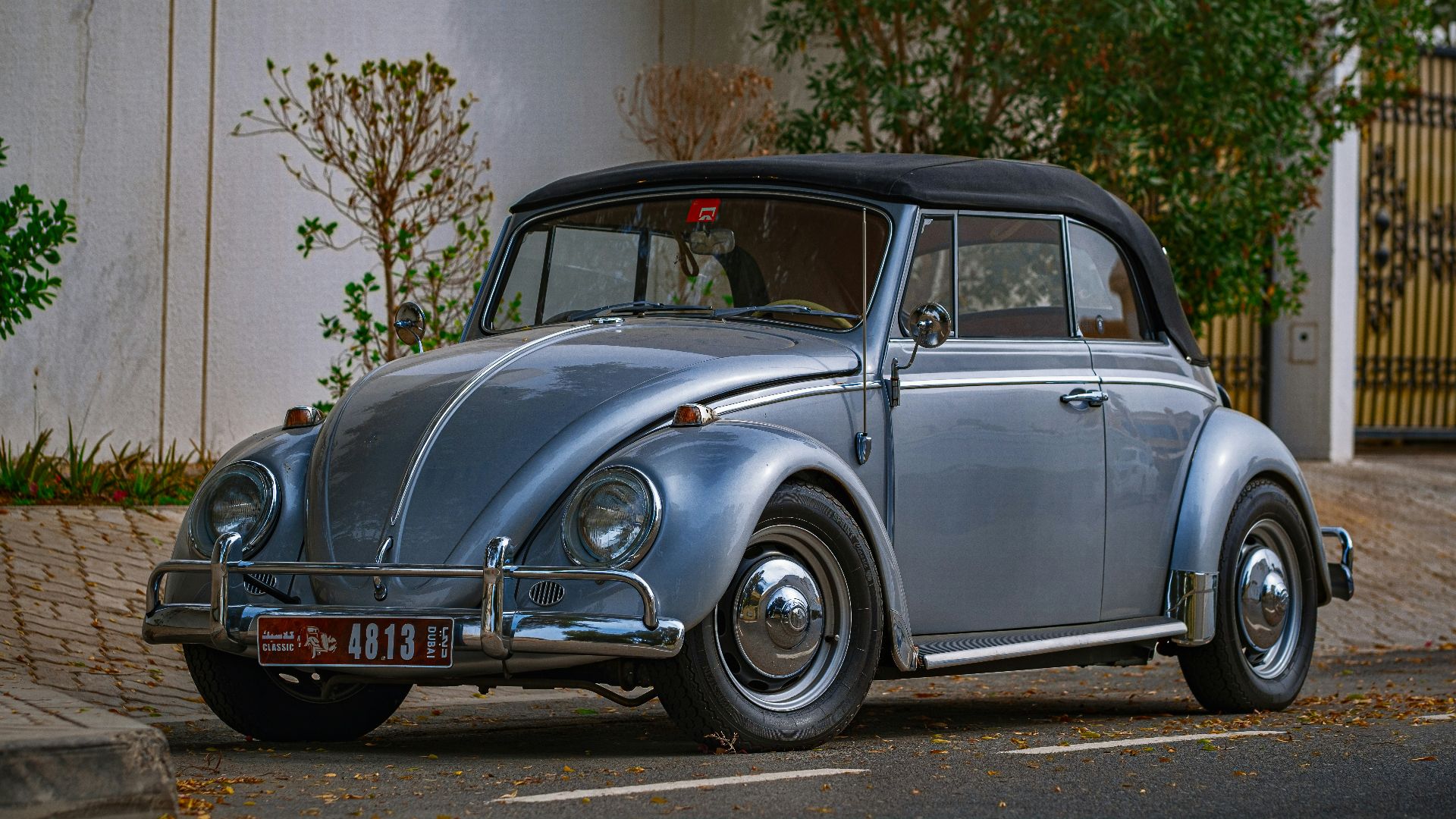 blue classic car parked near white building