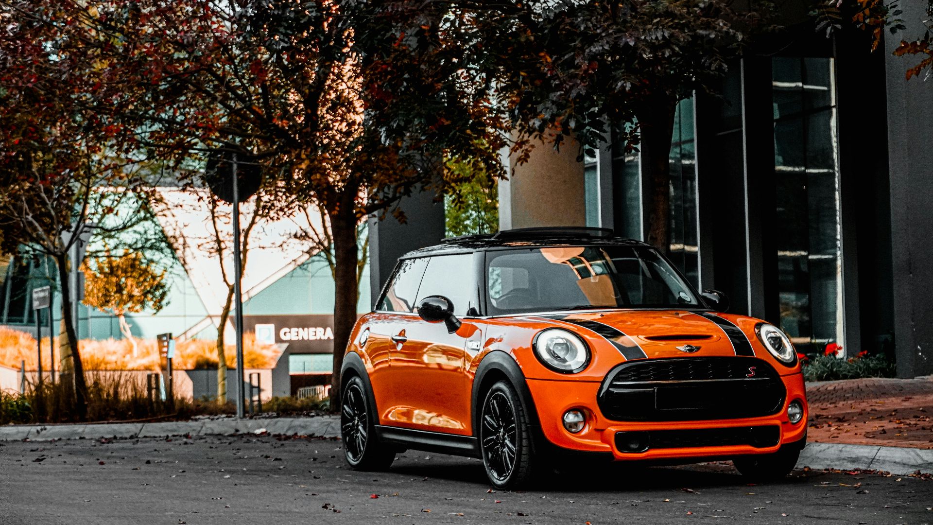 orange bmw m 3 parked on sidewalk during daytime