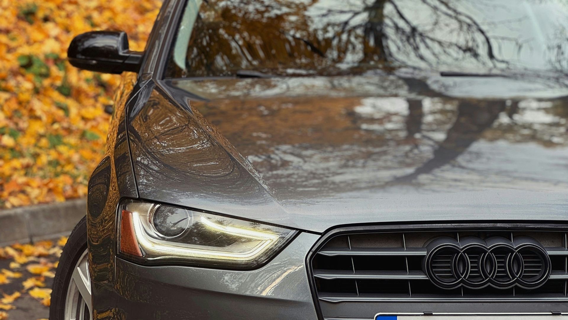 A grey car parked on the side of a road