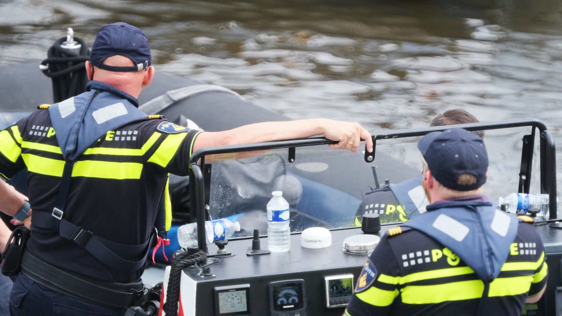 A couple of men standing on top of a boat