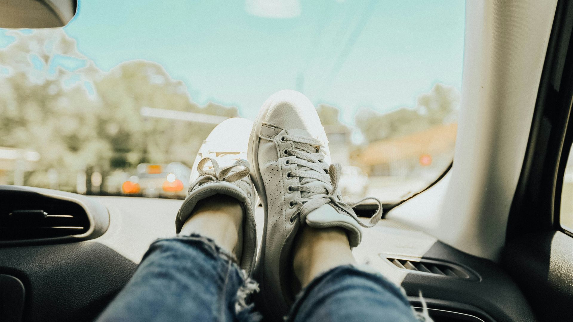 person resting feet on car dashboard