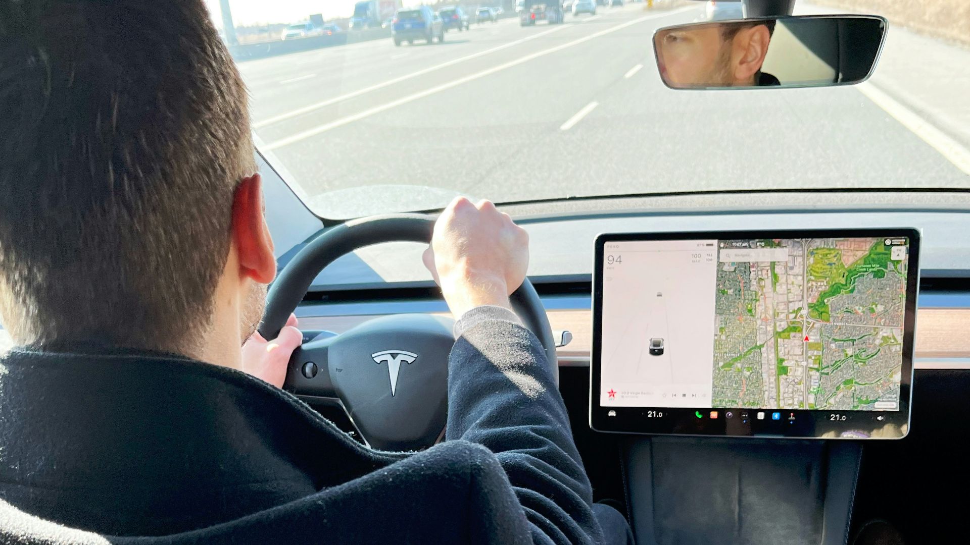 a man driving a car while holding a tablet